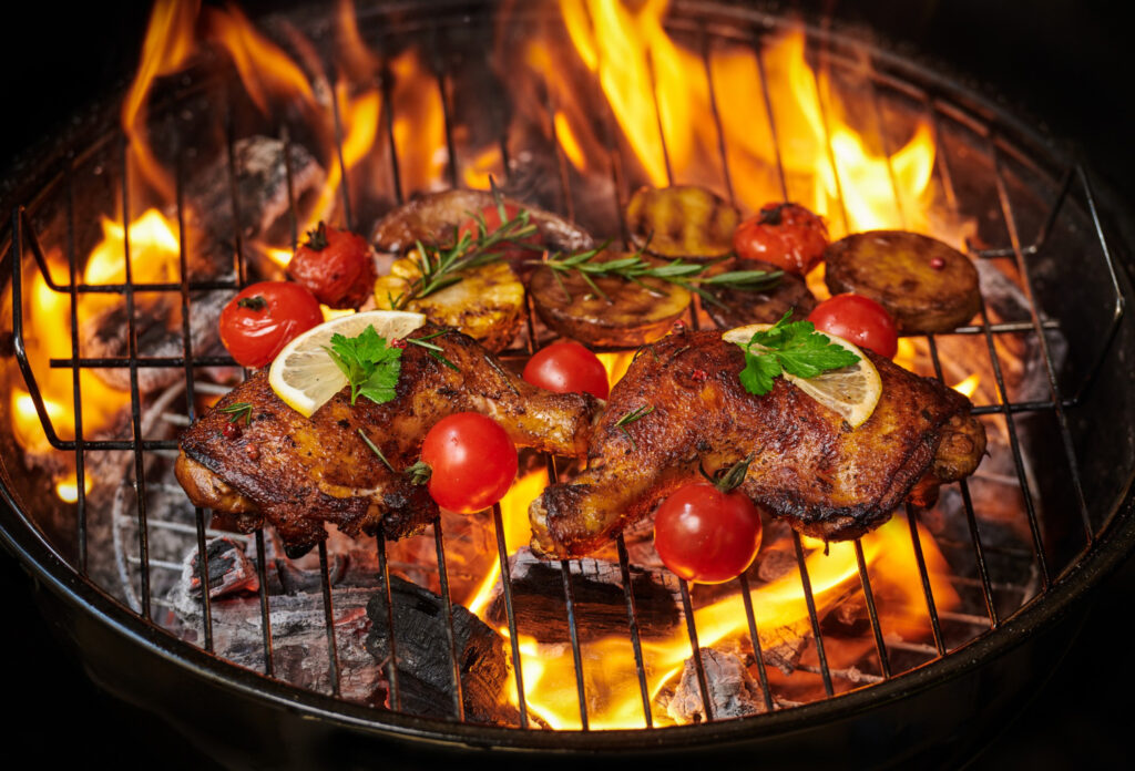 grilled-chicken-legs-flaming-grill-with-grilled-vegetables-with-tomatoes-potatoes-pepper-seeds-salt